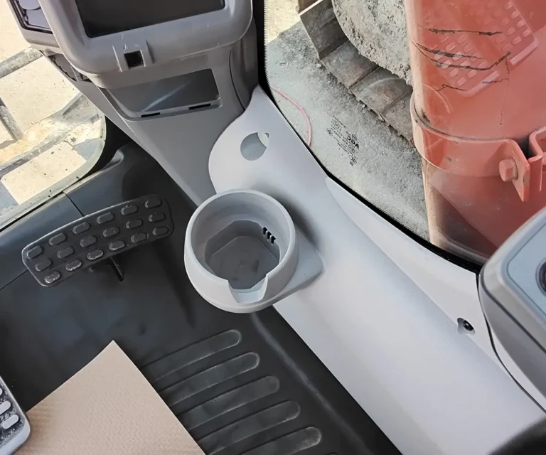 Spotless excavator cab interior console, cupholder, and foot pedals after mobile interior detailing in Calgary by Anderson Fleet Restoration
